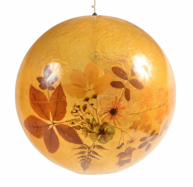Trois suspensions boules en résine jaune à décor intercalaire de fleurs séchées…