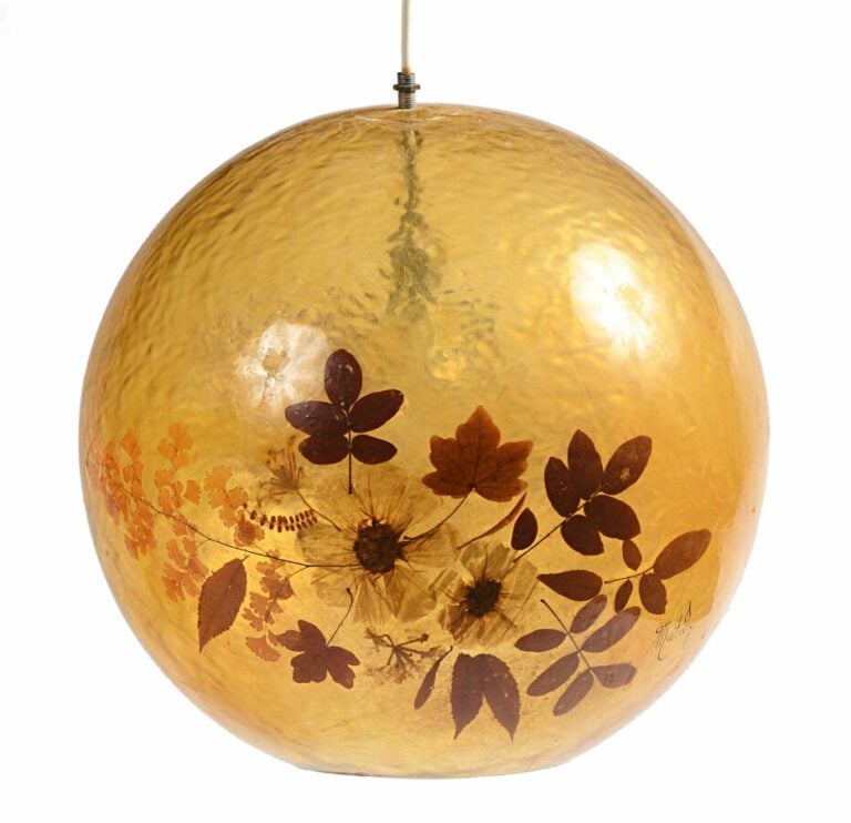 Trois suspensions boules en résine jaune à décor intercalaire de fleurs séchées…