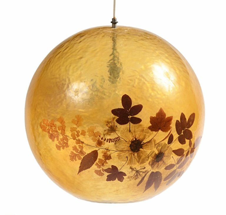 Trois suspensions boules en résine jaune à décor intercalaire de fleurs séchées…