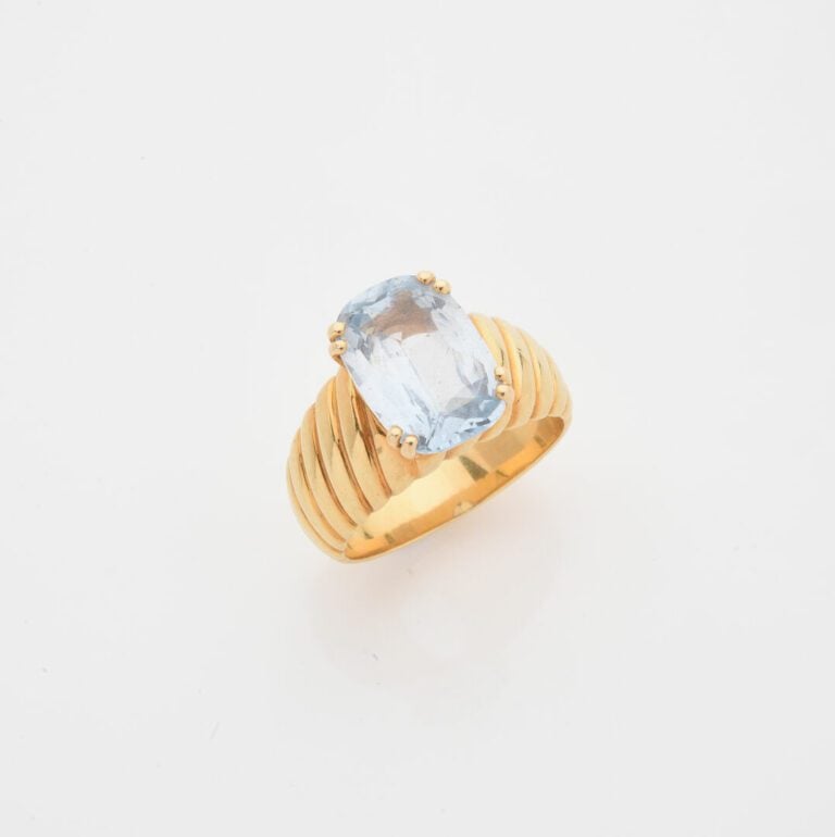 Bague bandeau en or jaune (750) centrée d'une aigue-marine de taille ovale face…