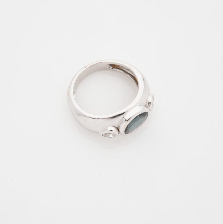 Bague jonc en or gris (750) ornée d'un saphir de taille ovale facettée, épaulé…