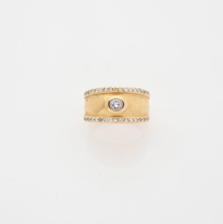 Bague jonc en or jaune (750) centrée d'un diamant taille brillant en serti clos…