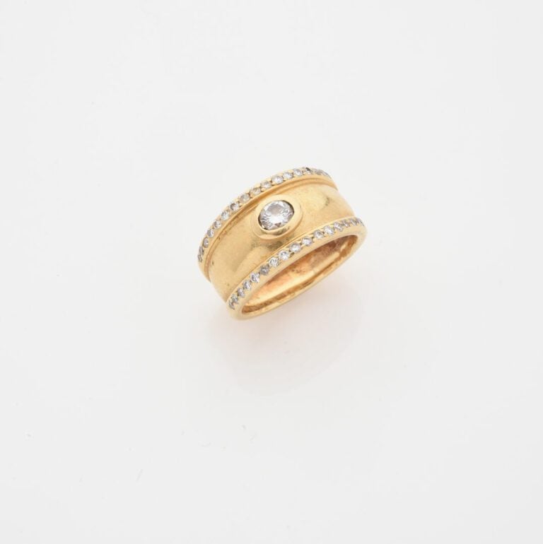 Bague jonc en or jaune (750) centrée d'un diamant taille brillant en serti clos…