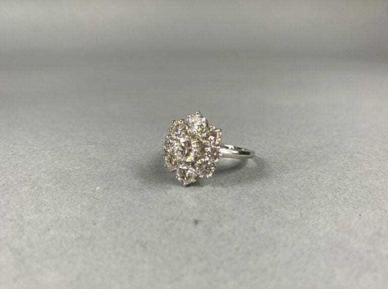 Bague marguerite en or gris (750) centrée d'un diamant taille brillant dans un…