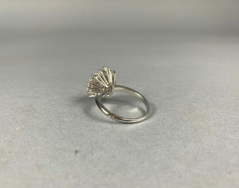 Bague marguerite en or gris (750) centrée d'un diamant taille brillant dans un…