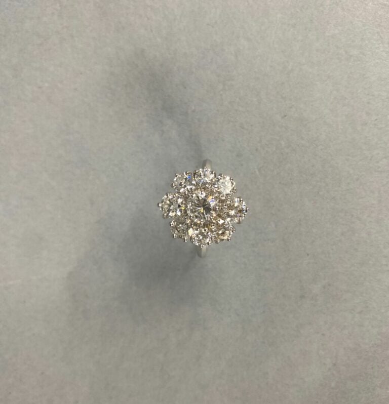 Bague marguerite en or gris (750) centrée d'un diamant taille brillant dans un…