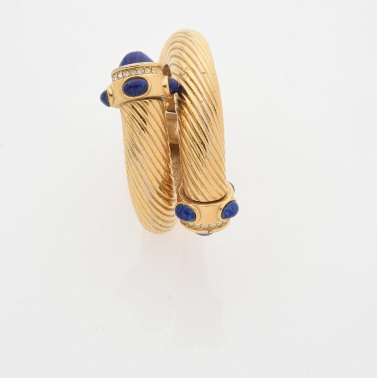 Bracelet jonc ouvrant en métal doré à motif rainuré orné aux extrémités de cabo…