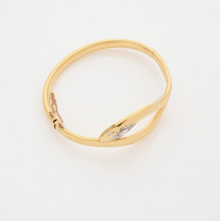 Bracelet jonc ouvrant en or jaune (750) figurant un serpent enroulé, la tête or…