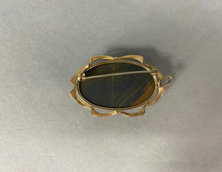 Broche ovale en or jaune (375) pouvant former pendentif ornée d'un cabochon d'o…