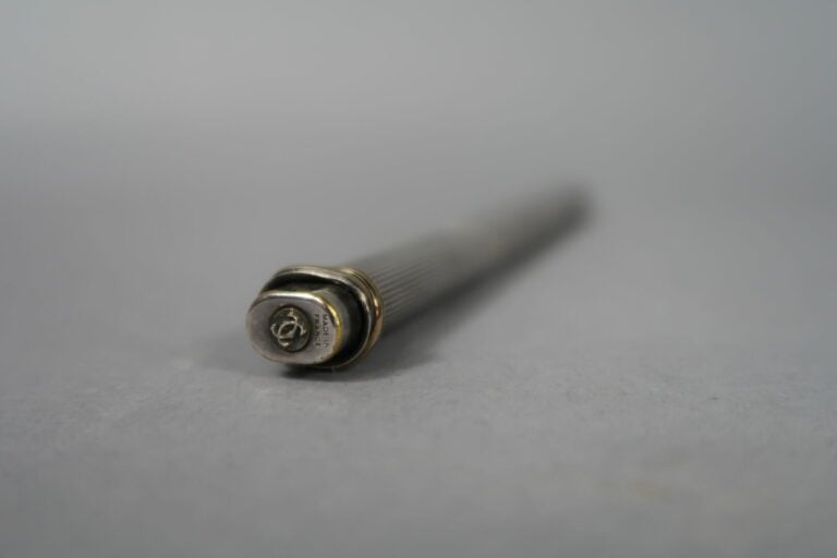 CARTIER, Trinity - Stylo bille en métal argenté rainuré et plaqué trois ors - (…