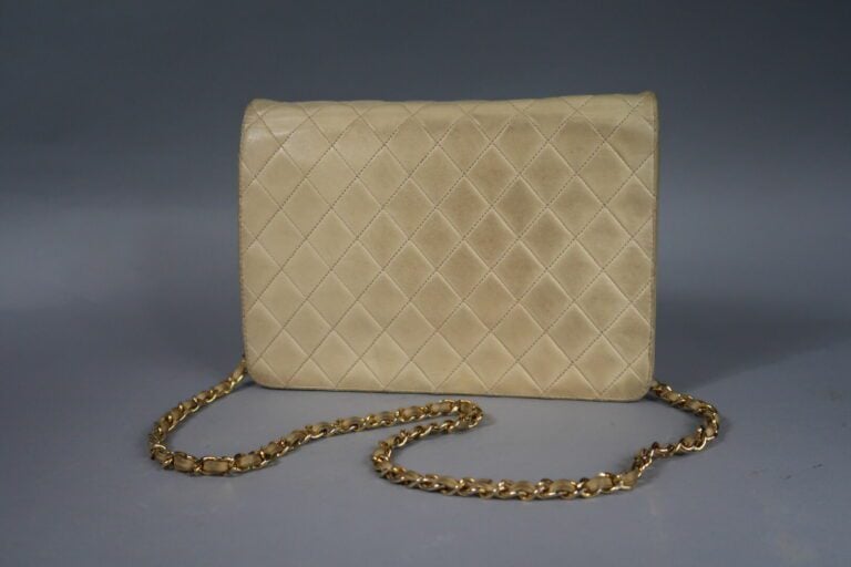 CHANEL - Sac 25 cm en cuir agneau matelassé crème, fermeture pression sur rabat…
