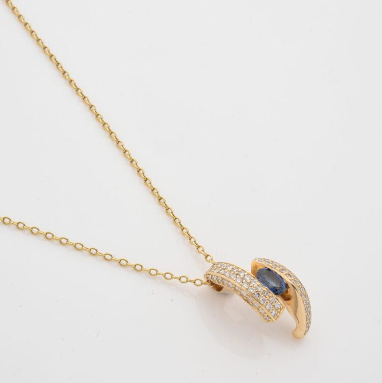 Chaîne en or jaune (750) à maille forçat retenant un pendentif asymétrique cent…