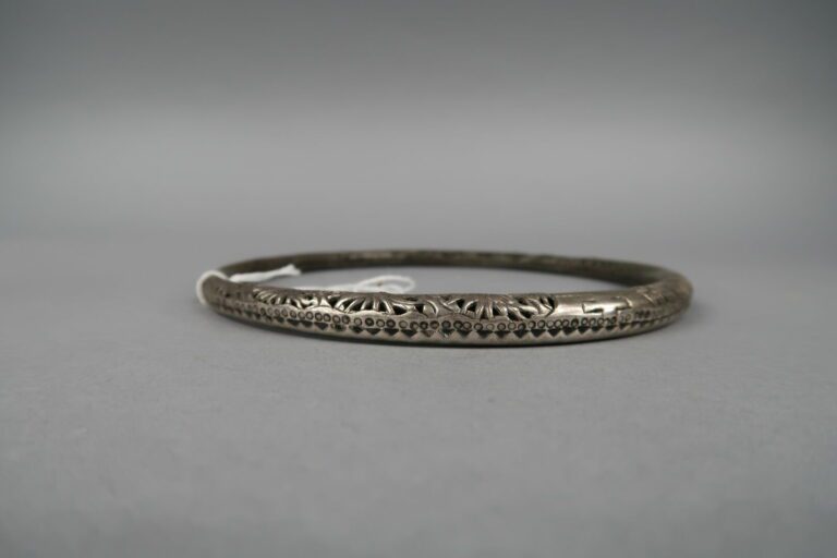 * Chine - Collier torque à un anneau en argent bas titre à décor ciselé et ajou…