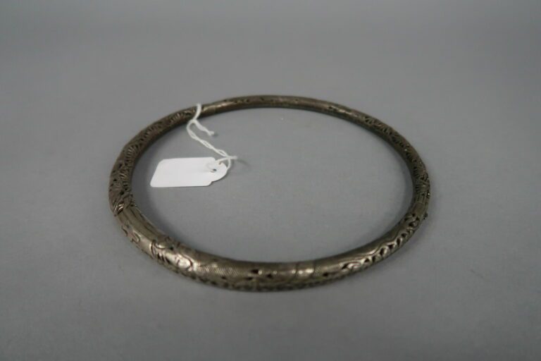 * Chine - Collier torque à un anneau en argent bas titre à décor ciselé et ajou…