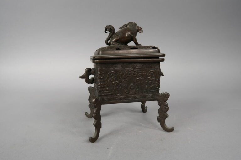 Chine, XXe siècle - Brûle parfum en bronze quadriopode à décor en léger relief…