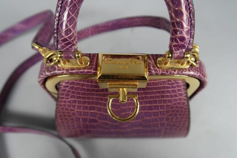 Christian DIOR - Petit sac de forme bourse en cuir façon croco violet, fermoir…