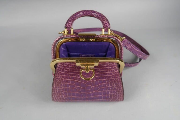 Christian DIOR - Petit sac de forme bourse en cuir façon croco violet, fermoir…