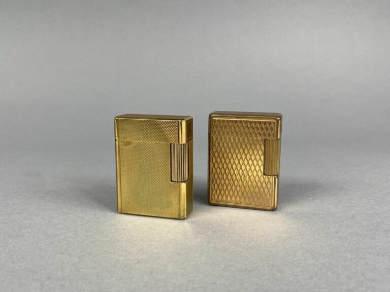 DUPONT - Lot de deux briquets en métal doré à décor guilloché - Numérotés…