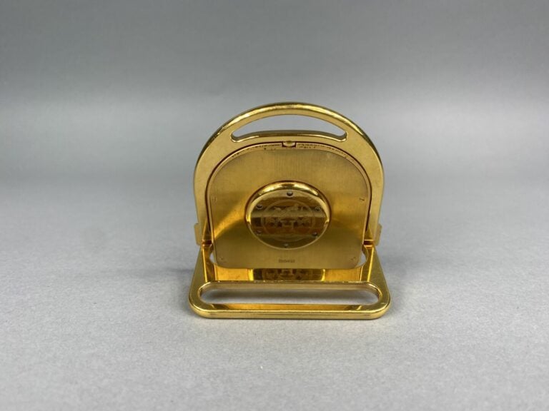 HERMES Paris - Pendulette de voyage "Etrier"en métal doré, cadran blanc et beig…
