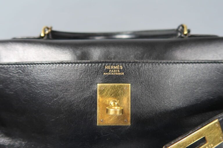 HERMES - Sac «Kelly retourné» 32cm en box noir, attributs dorés, clefs, clochet…