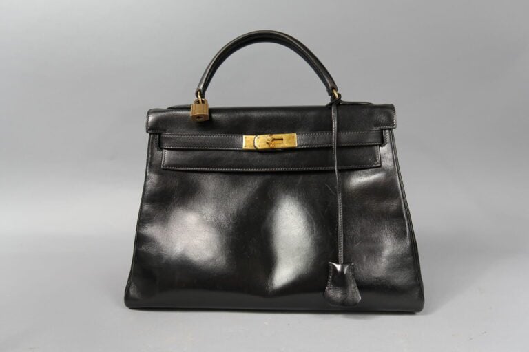 HERMES - Sac «Kelly retourné» 32cm en box noir, attributs dorés, clefs, clochet…