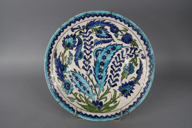 IZNIK. XXe siècle - Assiette en faïence à décor polychrome d'oeillets. - On joi…