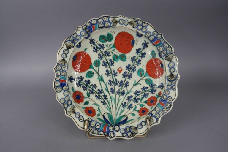 IZNIK. XXe siècle - Assiette en faïence à décor polychrome d'oeillets. - On joi…