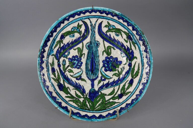 IZNIK. XXe siècle - Assiette en faïence à décor polychrome d'oeillets. - On joi…