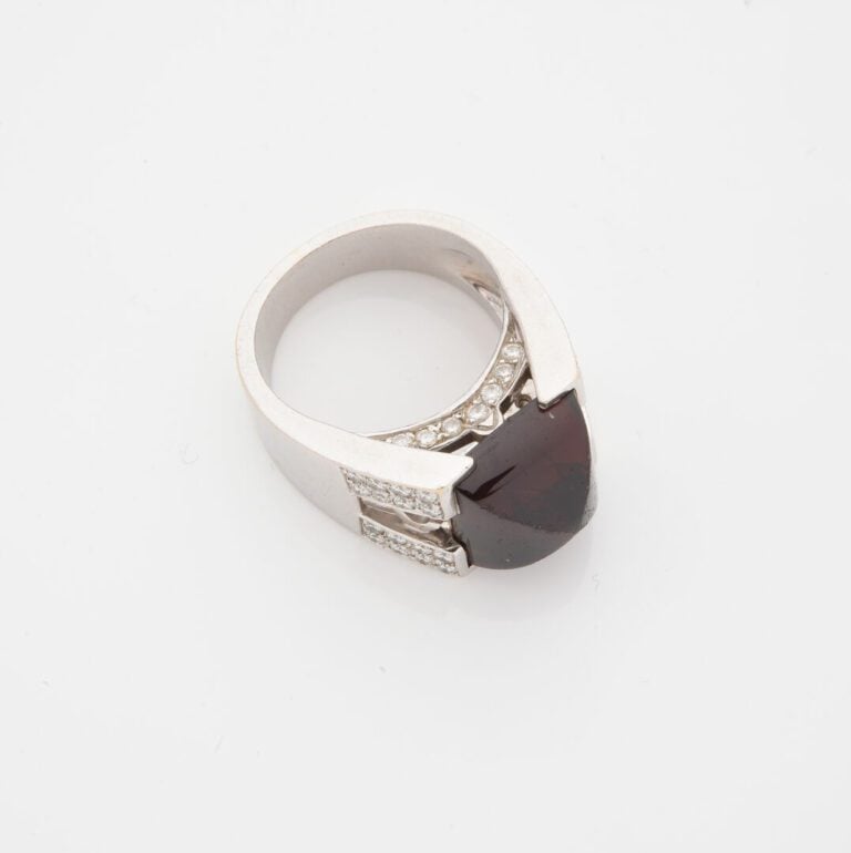 Importante bague en or gris (750) à monture ajourée ornée d'un cabochon de gren…