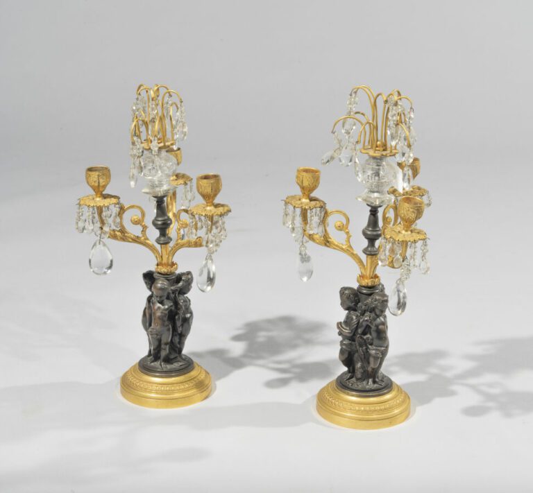 Paire de candélabres à trois lumières en bronze patiné et doré, fûts à décor d'…