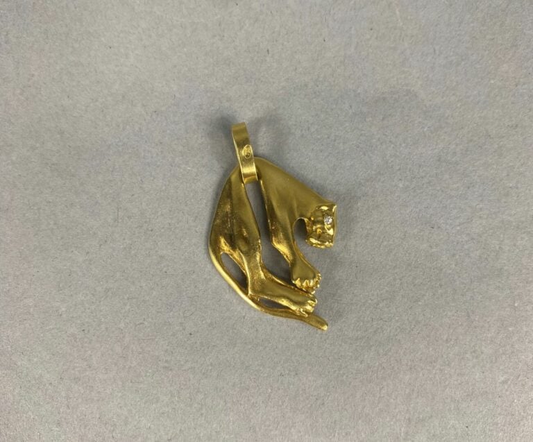 Pendentif en or jaune (750) figurant une panthère, les yeux sertis d'une petite…