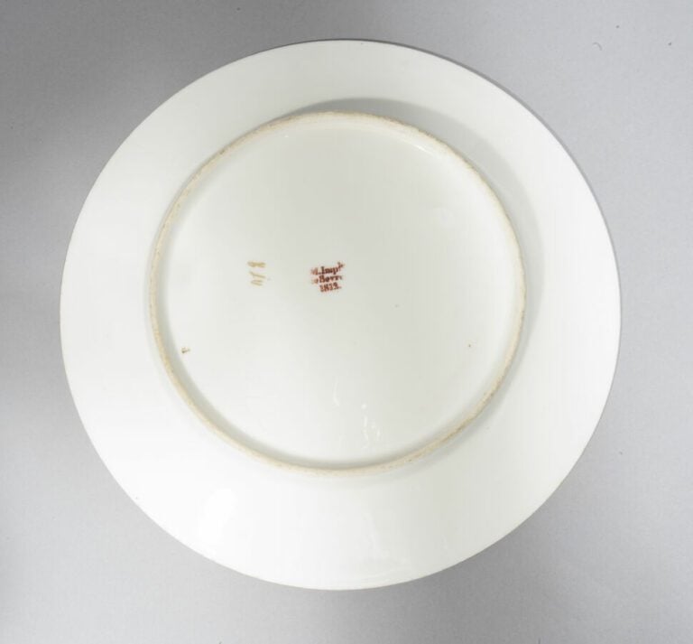 SEVRES - Ensemble de 12 assiettes décorées d'une rosace feuillagée or au centre…