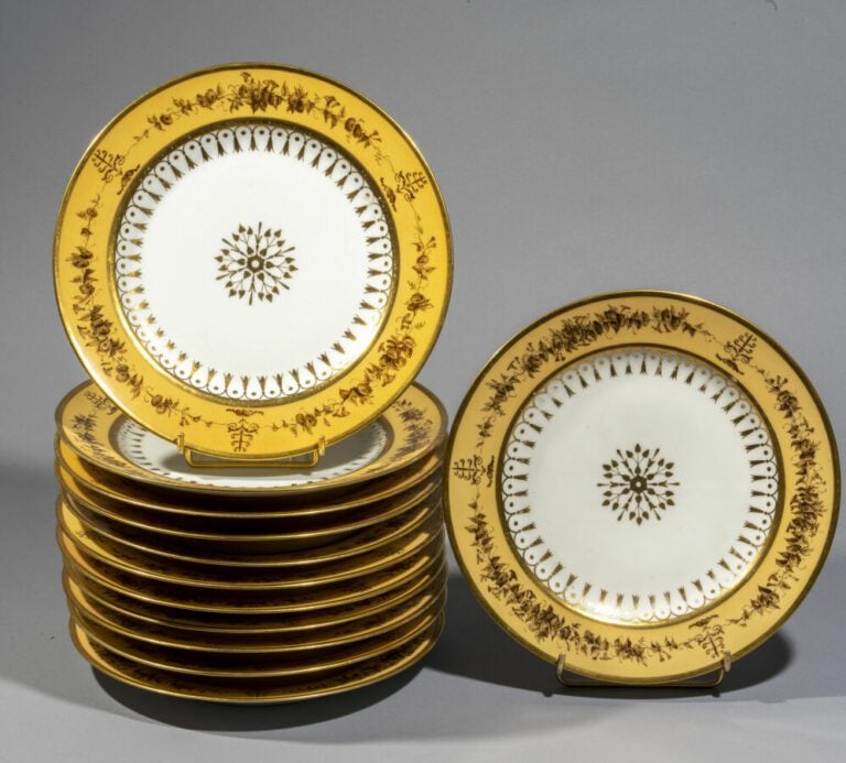 SEVRES - Ensemble de 12 assiettes décorées d'une rosace feuillagée or au centre…
