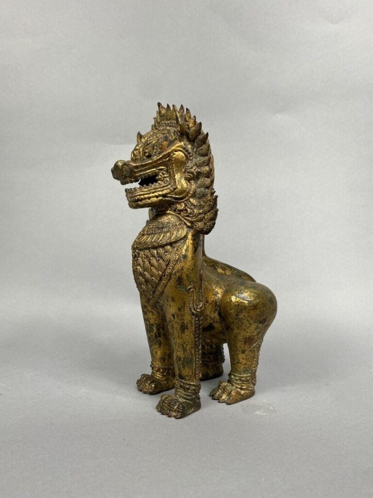 Thailande - XXe siècle - Statuette de lion en bronze laqué or, campé sur ses qu…