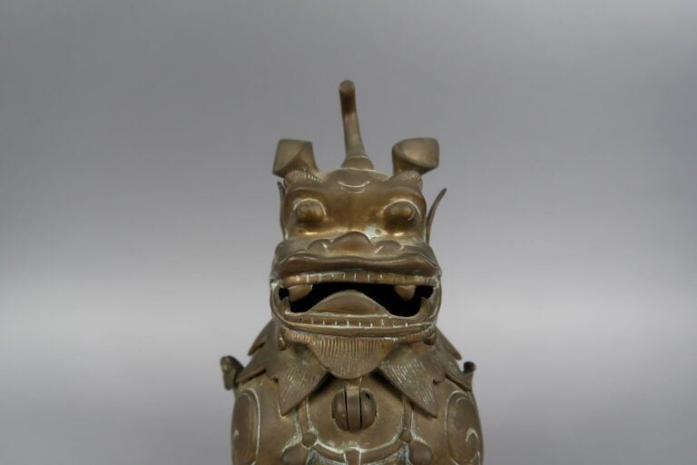 Vietnam, vers 1900 - Brûle-parfum en bronze dépatiné se tenant debout la gueule…