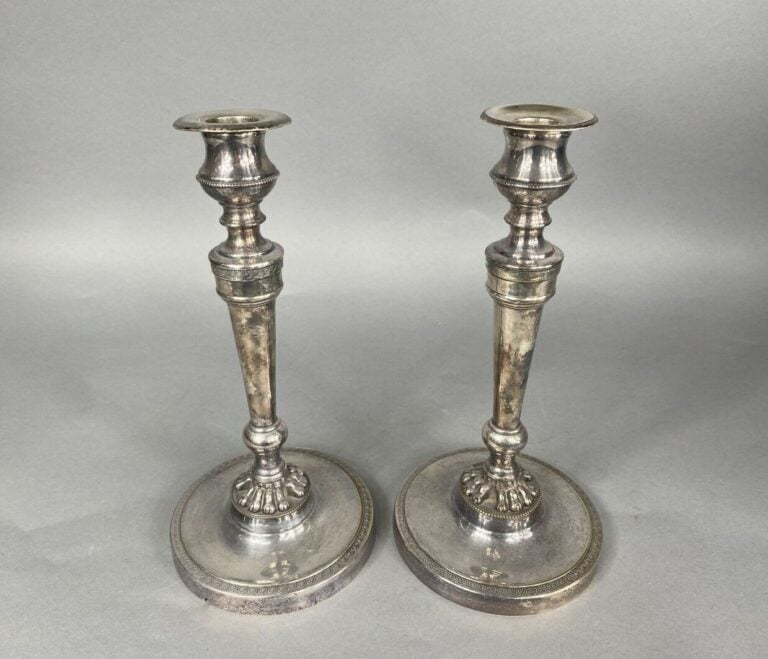 Paire de bougeoirs en métal argenté à décor de frises de perles et palmettes, l…