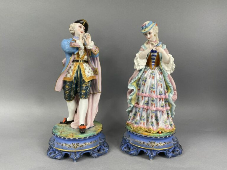 Deux sujets en porcelaine polychrome représentant un couple d'élégants sur un s…