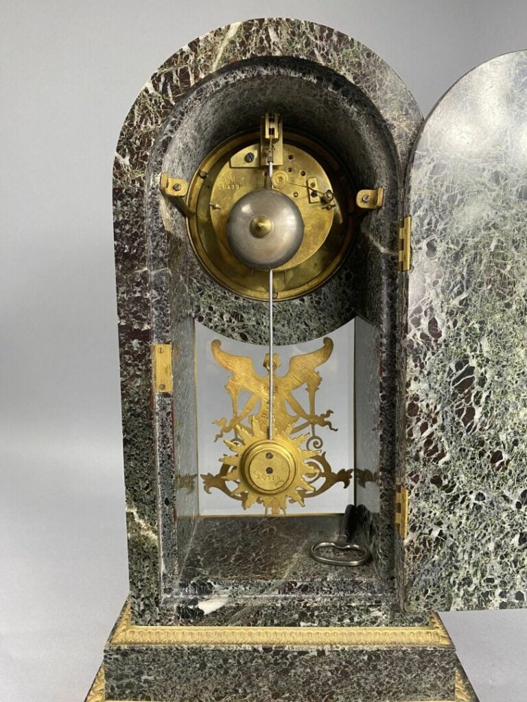 Pendule borne en marbre vert et bronze doré à décor de Renommée et frises de sp…