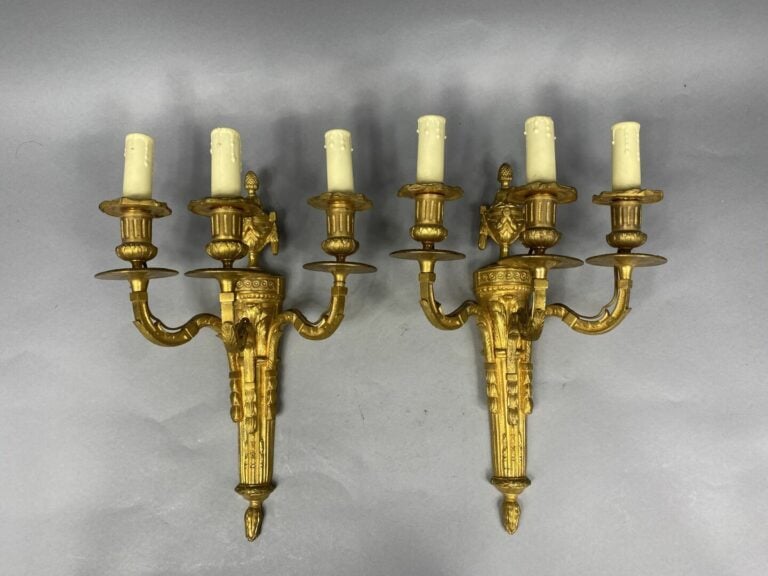 Paire d'appliques en bronze ciselé et doré à trois lumières, le fût en forme de…