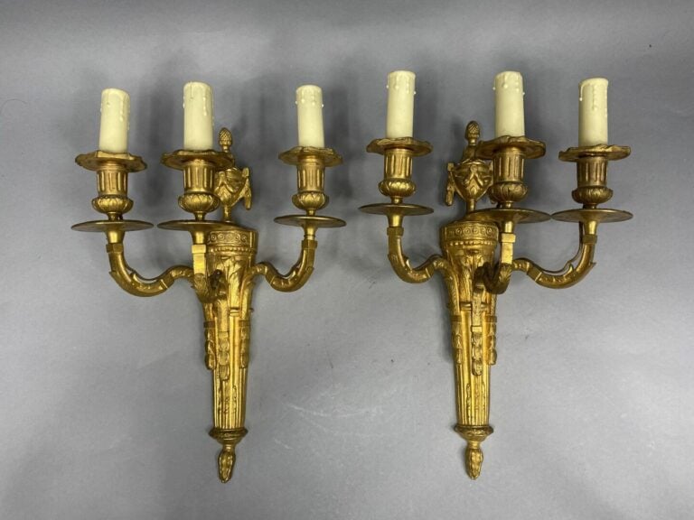 Paire d'appliques en bronze ciselé et doré à trois lumières, le fût en forme de…