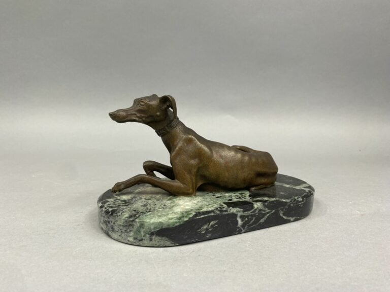Epreuve en bronze à patine brune représentant un lévrier couché posant sur un s…