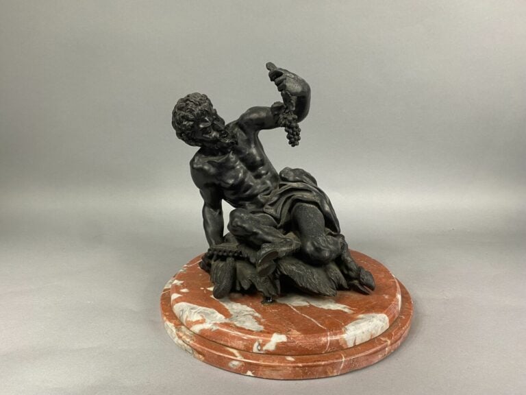 Epreuve en bronze à patine foncé figurant le Dieu Paon assis s'apprêtant à mang…