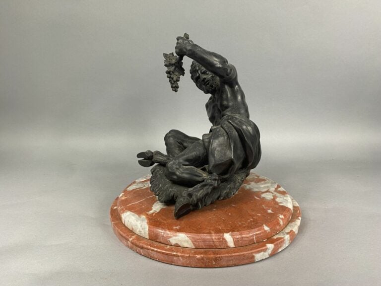 Epreuve en bronze à patine foncé figurant le Dieu Paon assis s'apprêtant à mang…