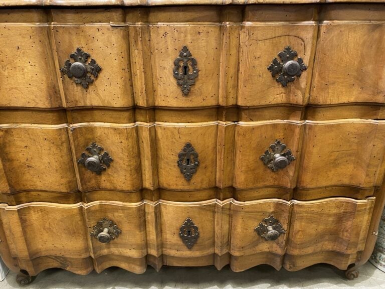 Commode en noyer à façade arbalète ouvrant à trois tiroirs, pieds à enroulement…