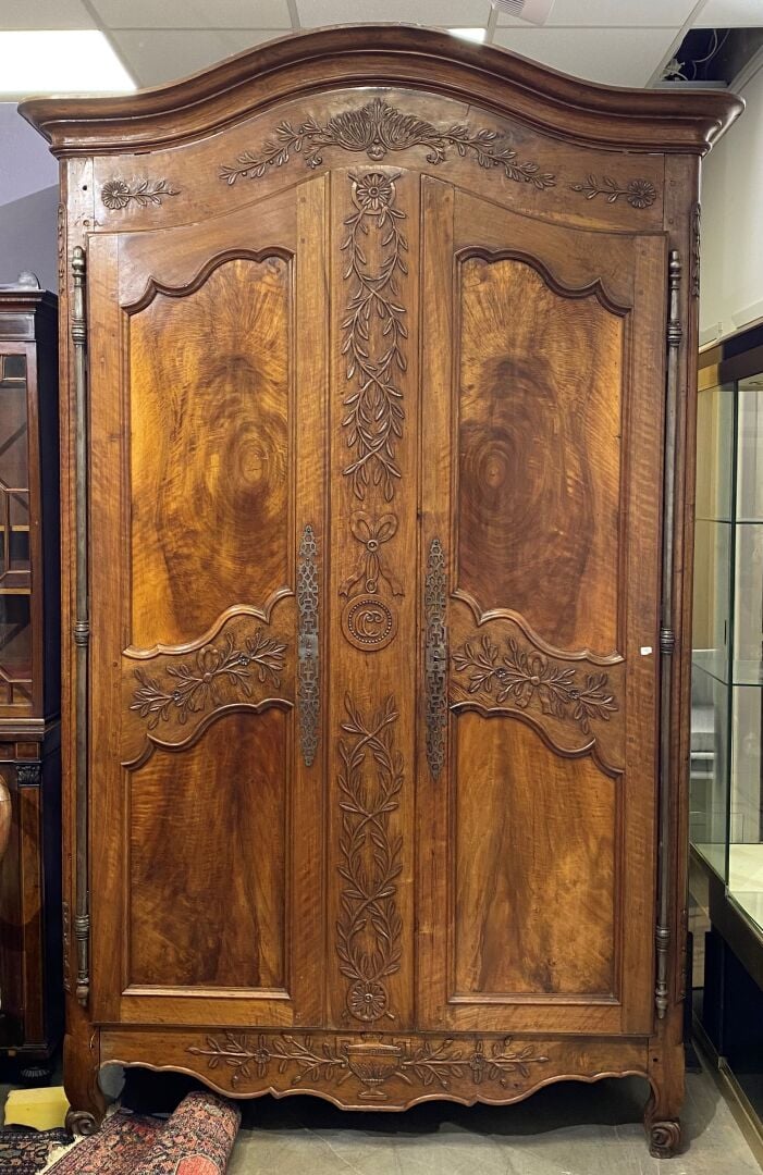 Grande armoire en noyer mouluré et sculpté ouvrant à deux portes à décor de bra…