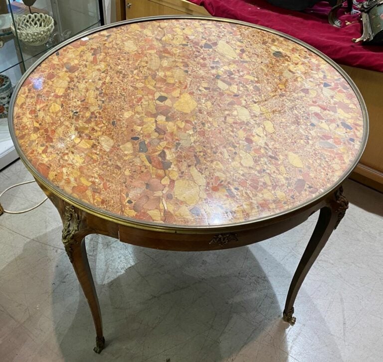 Grande table bouillotte en bois marqueté, ouvrant en ceinture par deux tiroirs…