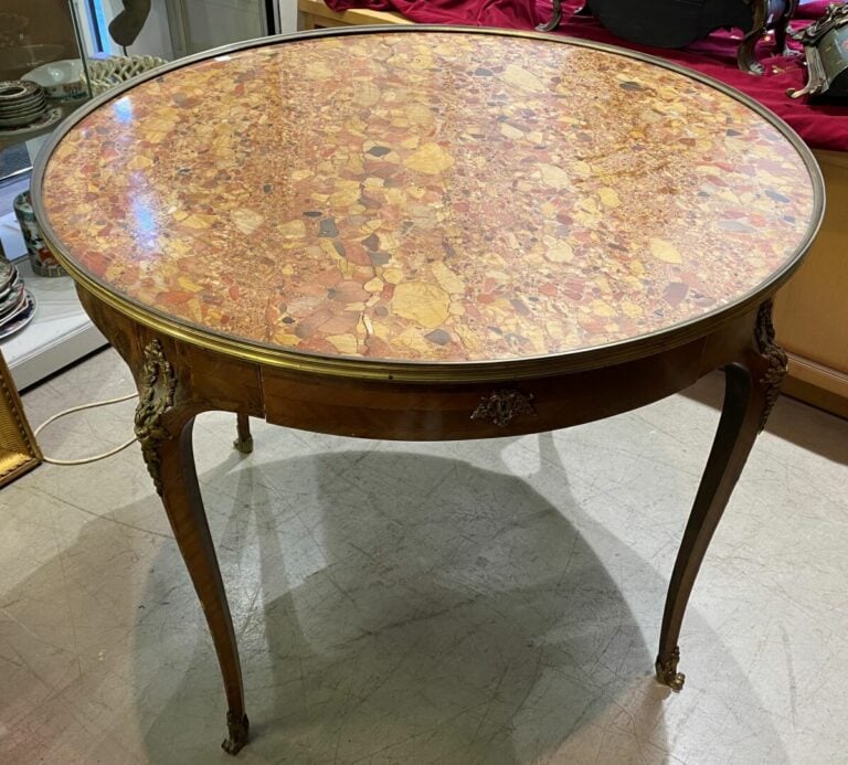 Grande table bouillotte en bois marqueté, ouvrant en ceinture par deux tiroirs…