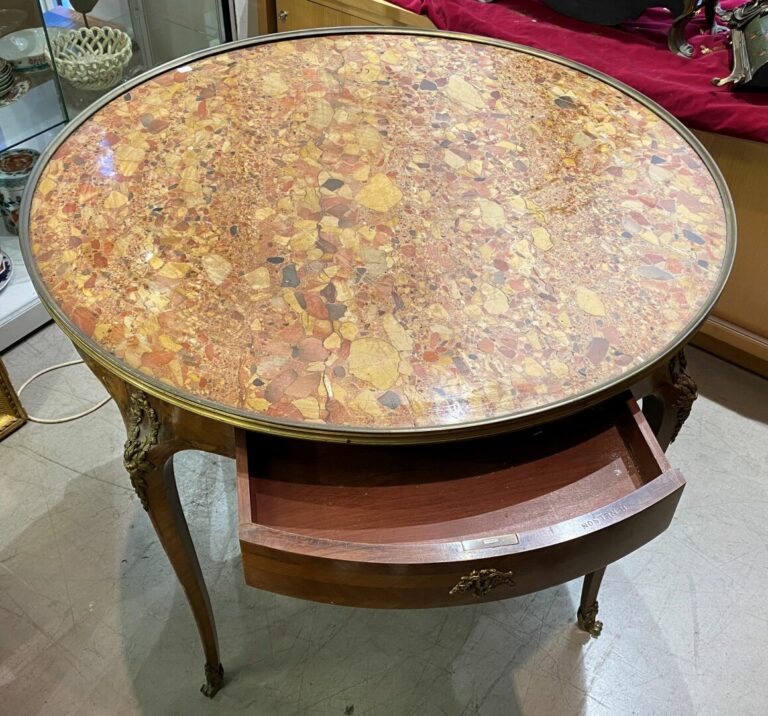 Grande table bouillotte en bois marqueté, ouvrant en ceinture par deux tiroirs…