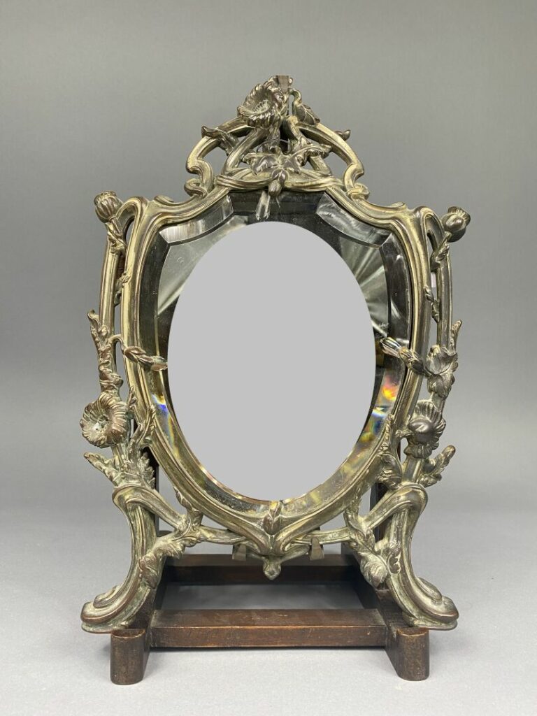 Miroir à poser, monture en bronze doré à décor de motifs floraux et enroulments…