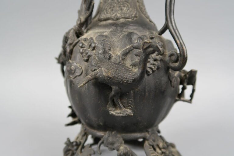 Chine - Verseuse en bronze à décor en relief de phénix, qilin, singe ... Le pie…